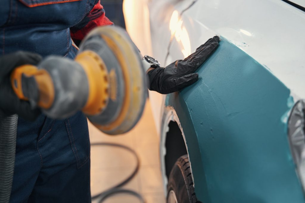 Close up of mechanic cleaning car body